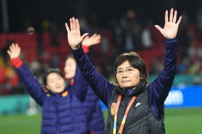 他坐在轮椅上拿着奖章庆祝属于他的这份至高无上的荣誉，周围人也前来替他高兴为他庆祝。